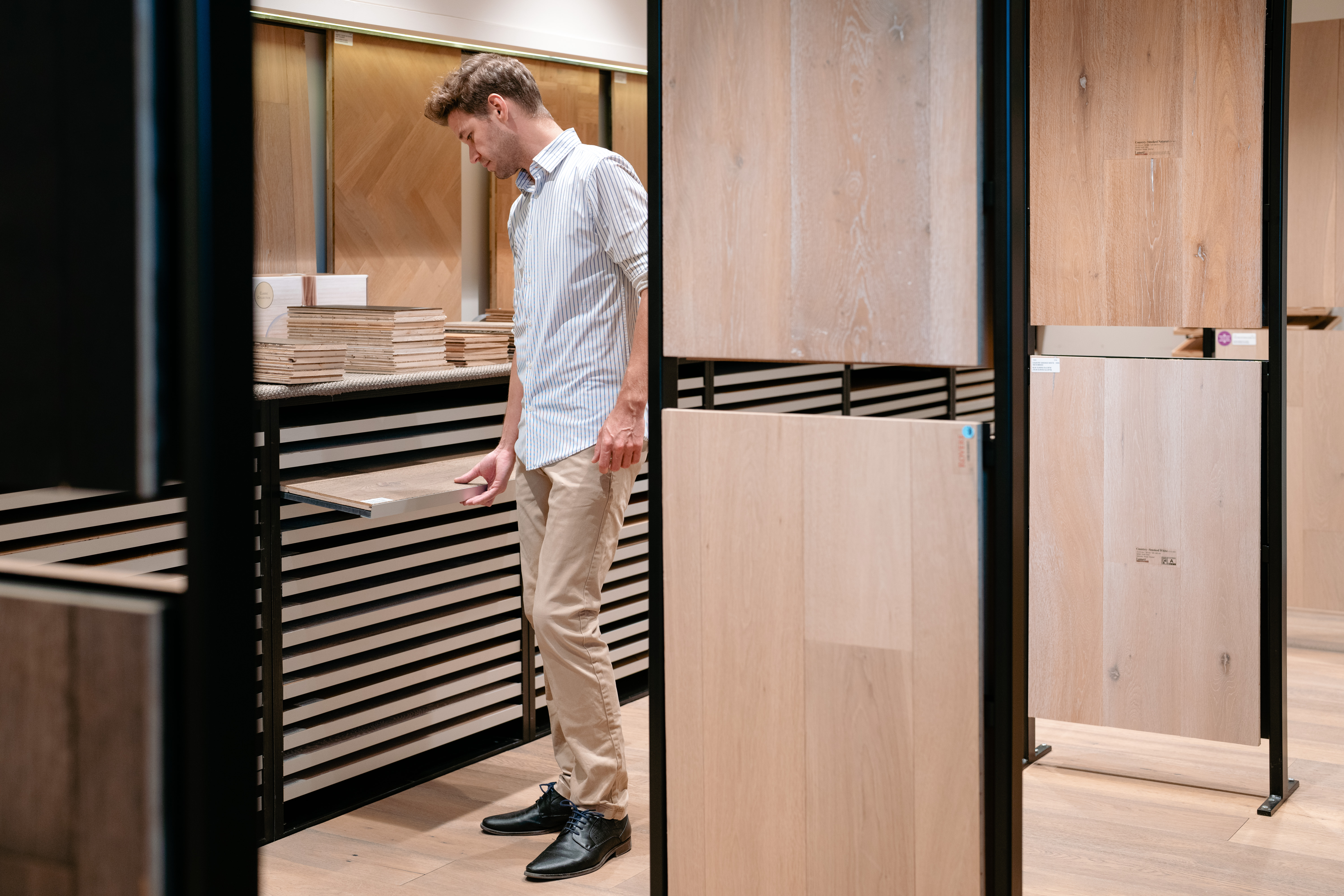 Een man kiest parket in de toonzaal van Wijckmans. 