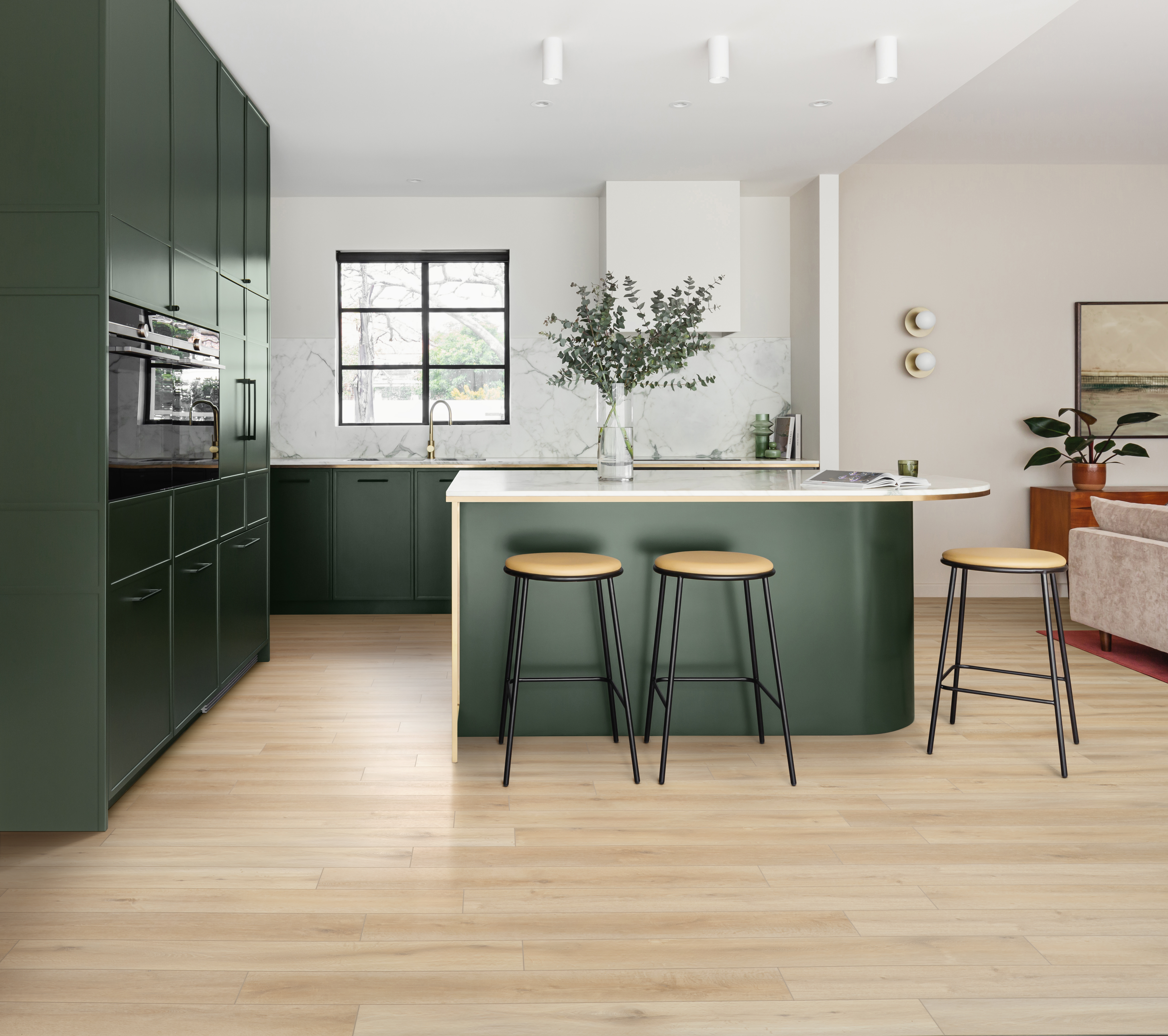 Een donkergroene keuken met parketvloer.