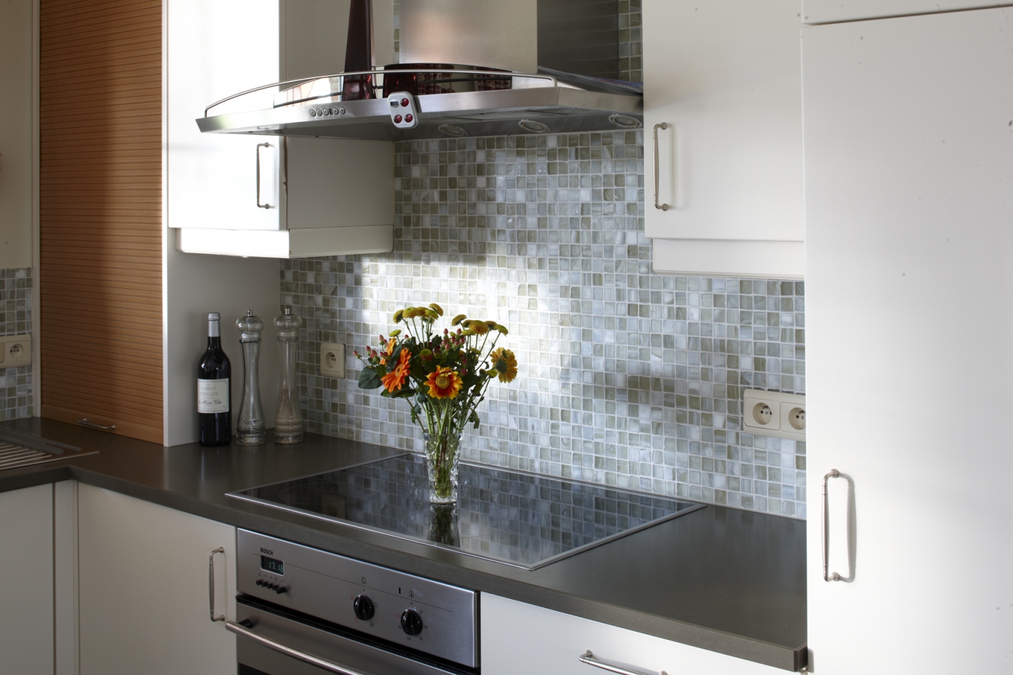 Wandtegels vormen een spatwand in de keuken achter het vuur.
